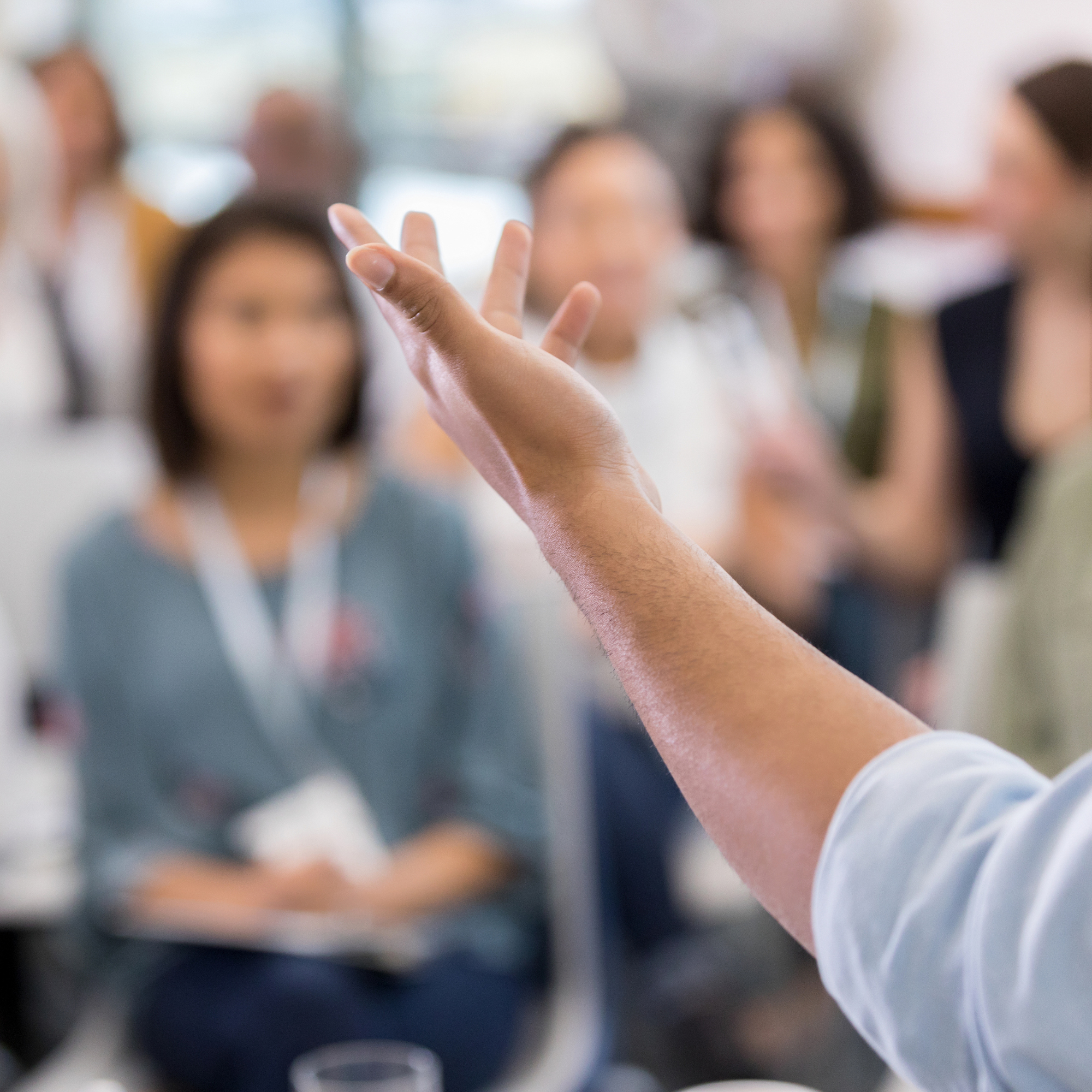 background of people blurry with an in focus arm at the forefront.